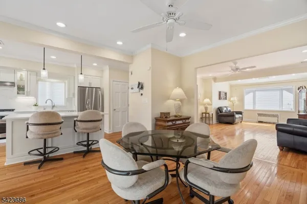 a living room with furniture kitchen view and a wooden floor