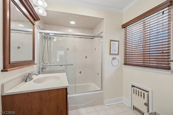 a bathroom with a granite countertop sink a toilet a mirror and shower