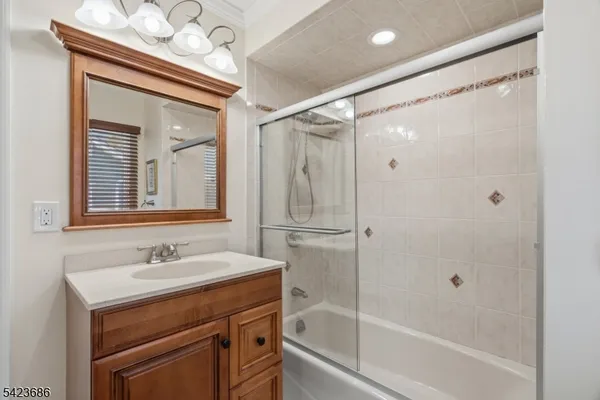 a bathroom with a shower sink vanity and mirror
