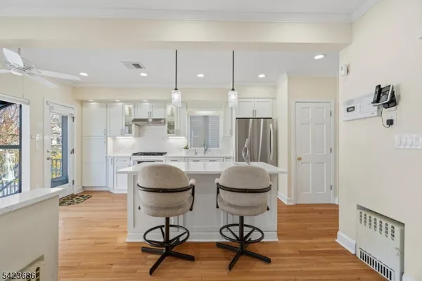 a room with a table chairs and a refrigerator