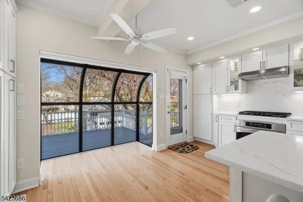 a kitchen with a stove a refrigerator and a view of living room