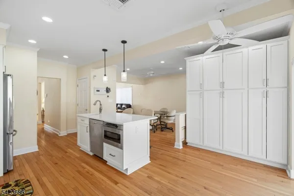 a large kitchen with white cabinets and stainless steel appliances