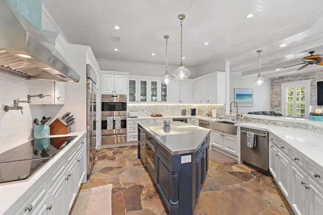 a kitchen with stainless steel appliances granite countertop a sink a stove and a refrigerator