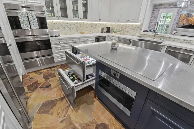 a kitchen with stainless steel appliances kitchen island wooden floors and white cabinets