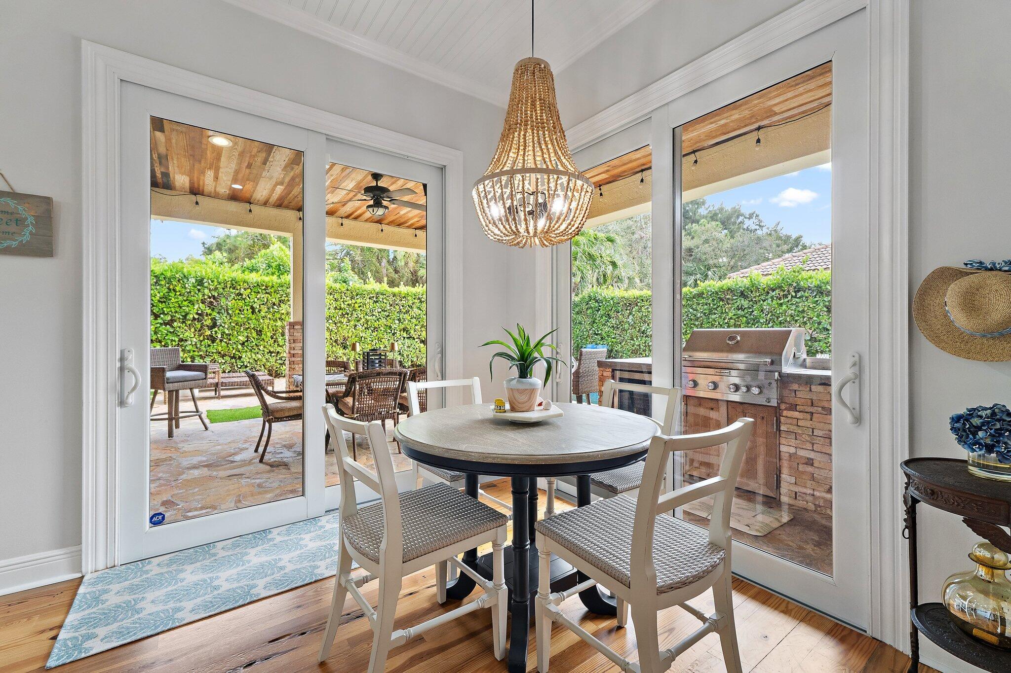 136 Via Catalunha Jupiter, FL 33458 - Photo 27 of 64 a view of a dining room with furniture large windows and wooden floor