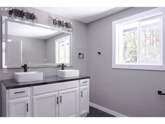 a bathroom with a sink a mirror and a window