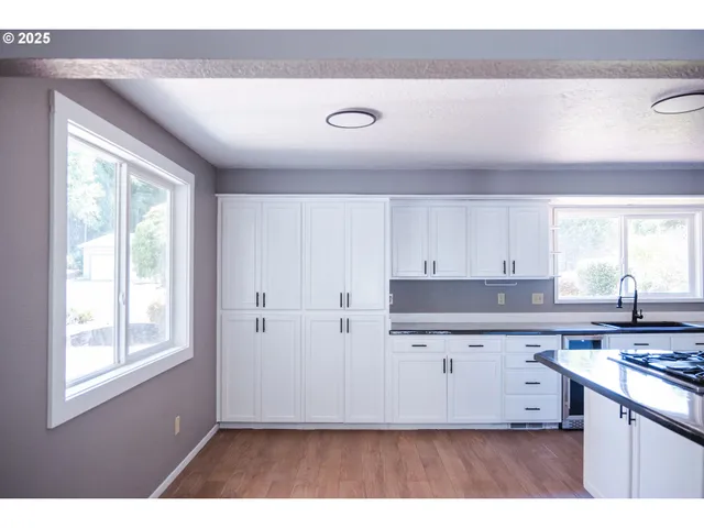 a kitchen with cabinets appliances and a window