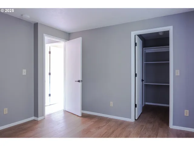 a view of an empty room with closet and a window