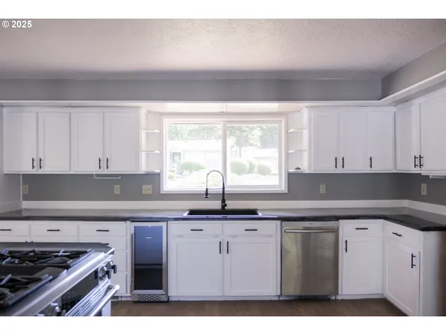 a kitchen with granite countertop a sink cabinets and window