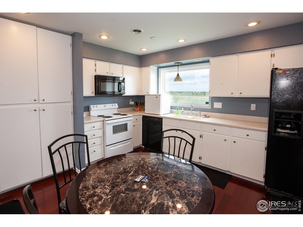 a kitchen with white cabinets a sink a stove and a refrigerator