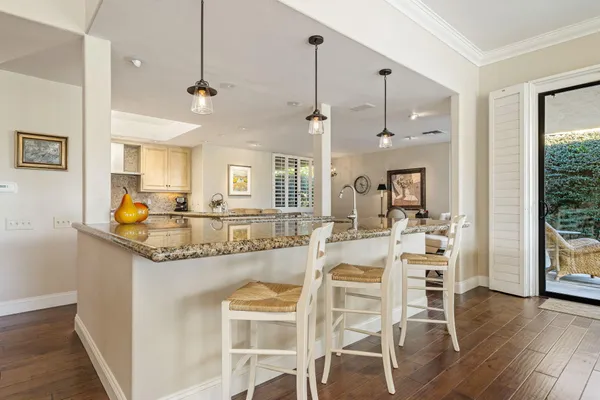 a view of a dining room and livingroom with furniture wooden floor a chandelier