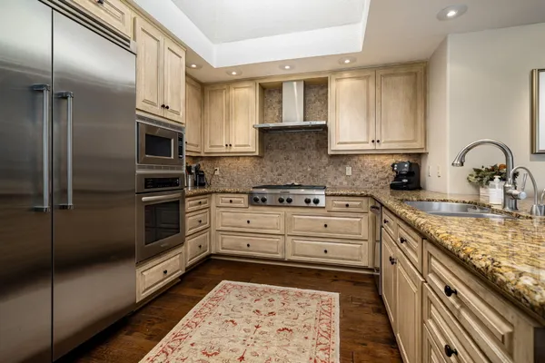 a kitchen with stainless steel appliances granite countertop a refrigerator microwave and stove