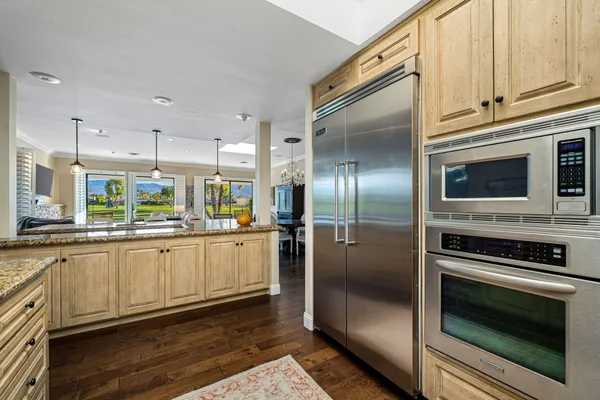 a living room with stainless steel appliances kitchen island granite countertop a couch and a large window