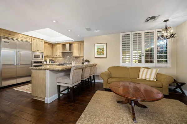 a living room with stainless steel appliances kitchen island granite countertop furniture and kitchen view