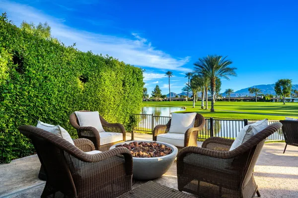 a view of a patio with couches table and chairs and potted plants