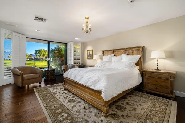 a spacious bedroom with a bed a couch and large windows