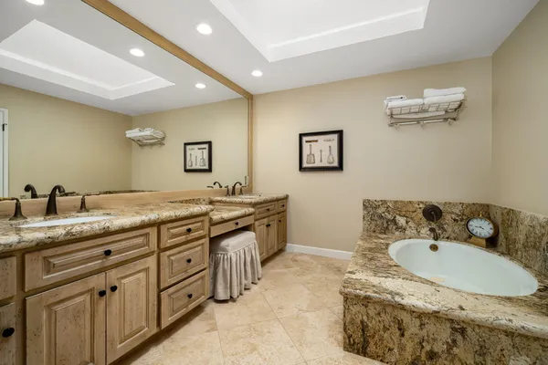 a bathroom with a granite countertop sink and a mirror