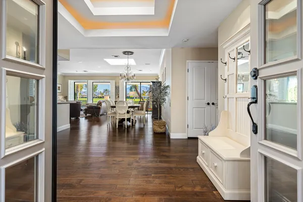 a view of a hallway with wooden floor and a living room