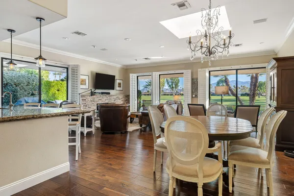 a dining room with furniture a chandelier and wooden floor