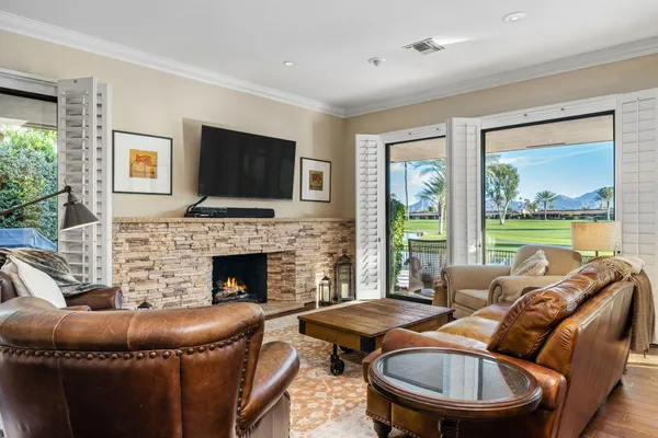 a living room with furniture a flat screen tv and a fireplace