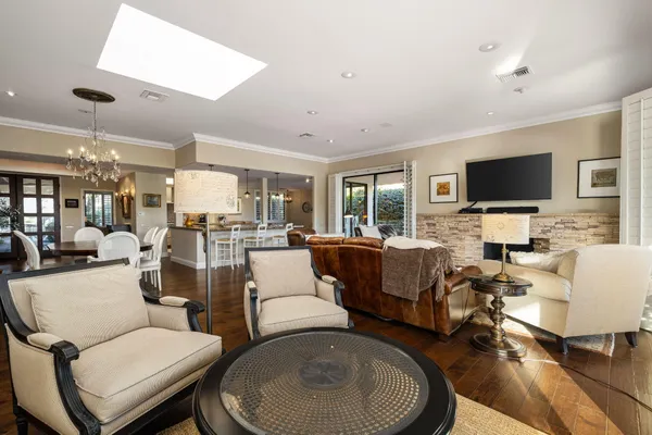 a living room with furniture a flat screen tv and a large window