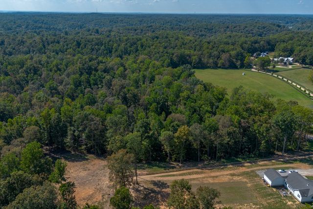 a view of a field with a building in the background