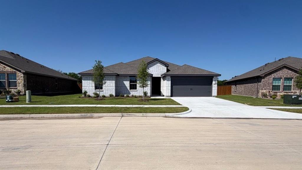 1913 Reveille Way Terrell, TX 75160 - Photo 28 of 35 Single-story residence featuring a light-colored brick exterior facade, a dark gray garage door, and a matching dark gray shingle roof