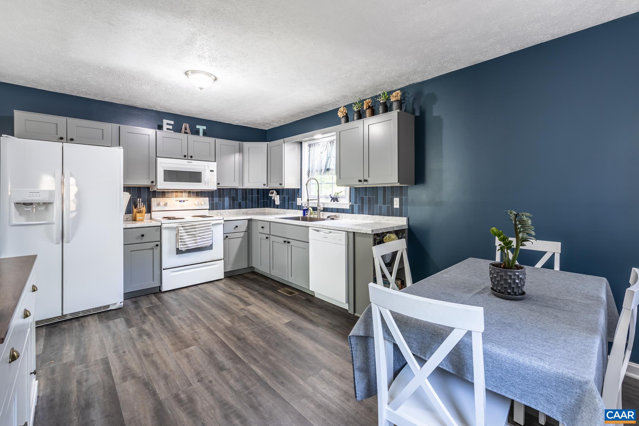 100 Holmes Run Road Stanardsville, VA 22973 - Photo 3 of 22 a kitchen with a table chairs refrigerator and cabinets