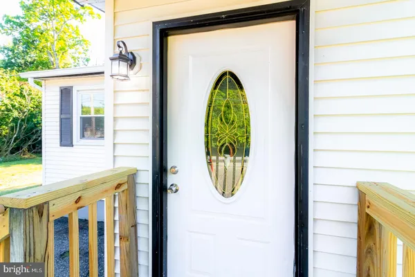 a view of a brick house with a potted plant and wooden fence