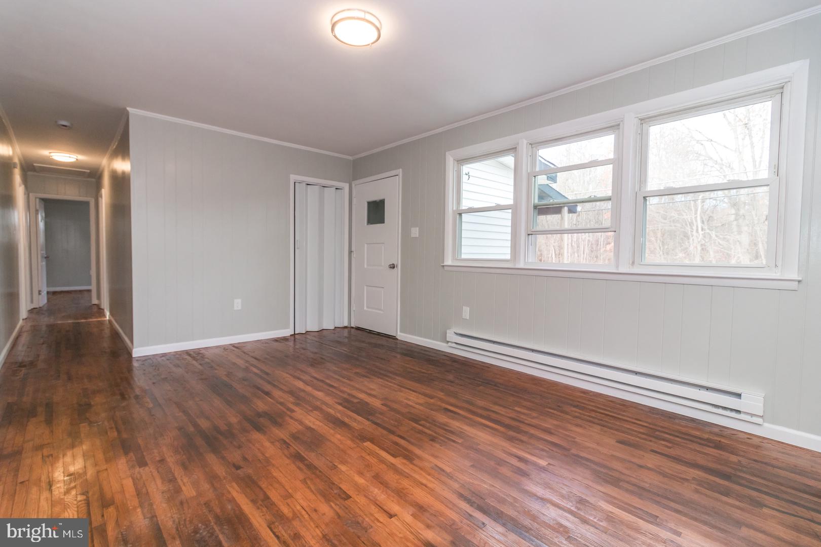 320 Fenwick Road Pilesgrove, NJ 08098 - Photo 12 of 18 an empty room with wooden floor and windows