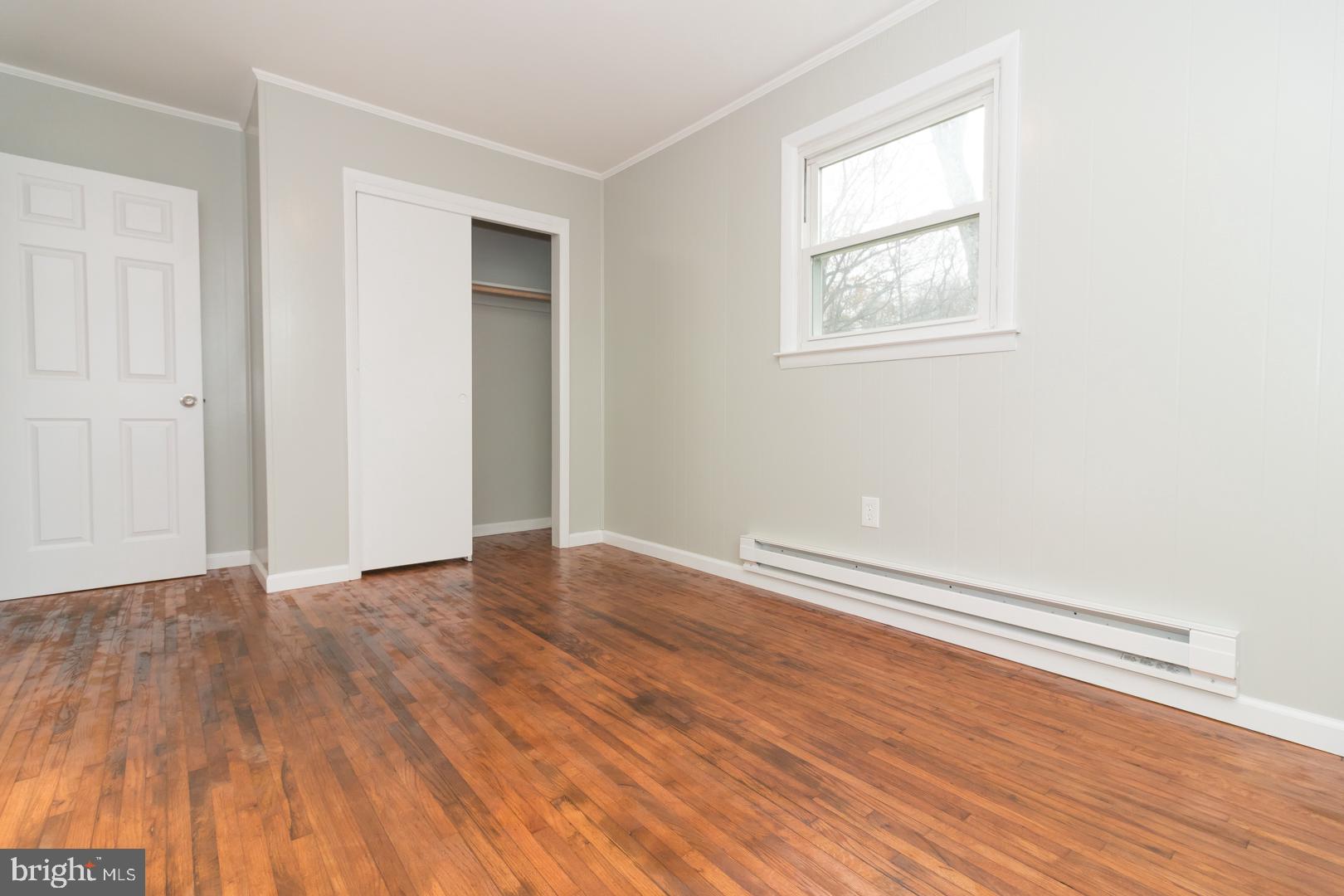 320 Fenwick Road Pilesgrove, NJ 08098 - Photo 13 of 18 an empty room with wooden floor and windows