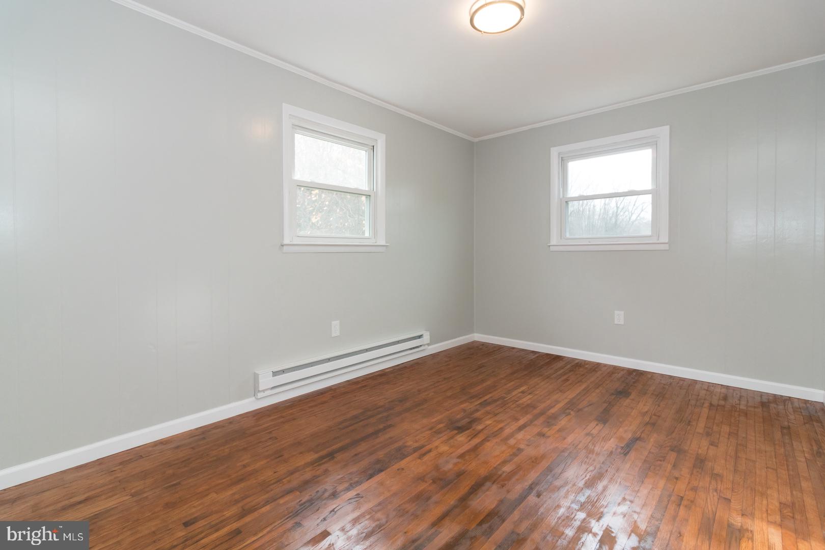 320 Fenwick Road Pilesgrove, NJ 08098 - Photo 14 of 18 an empty room with wooden floor and windows