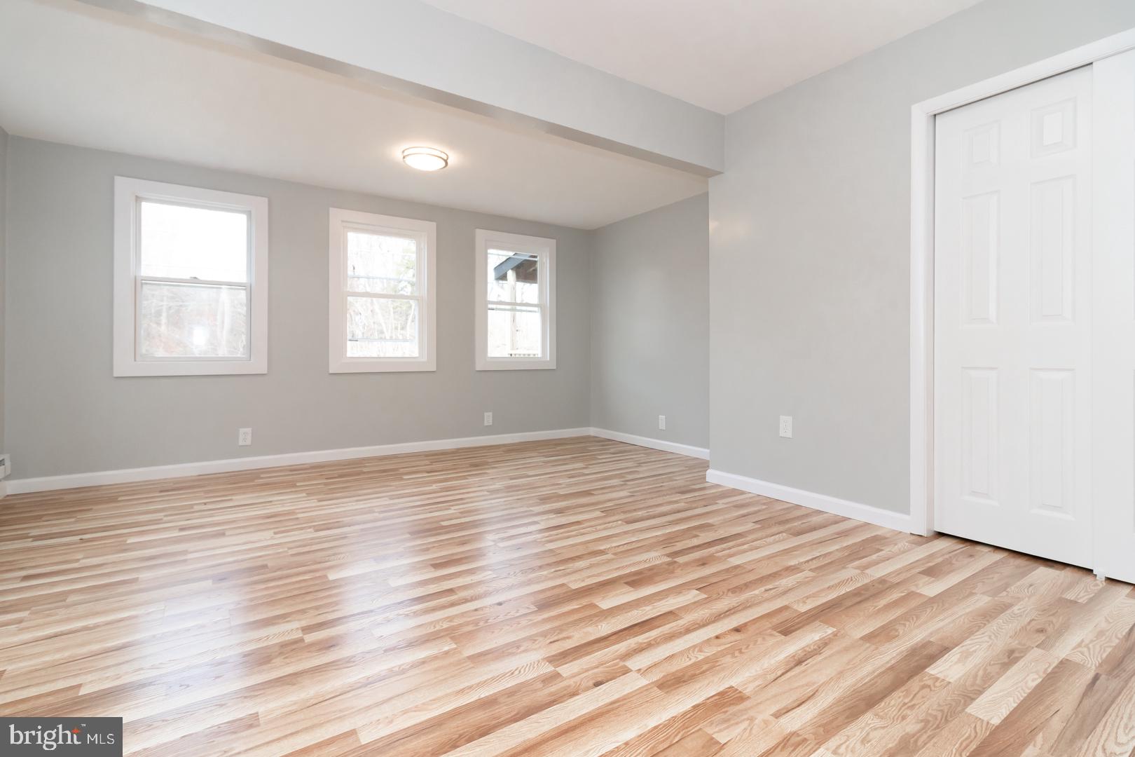 320 Fenwick Road Pilesgrove, NJ 08098 - Photo 6 of 18 an empty room with wooden floor and windows