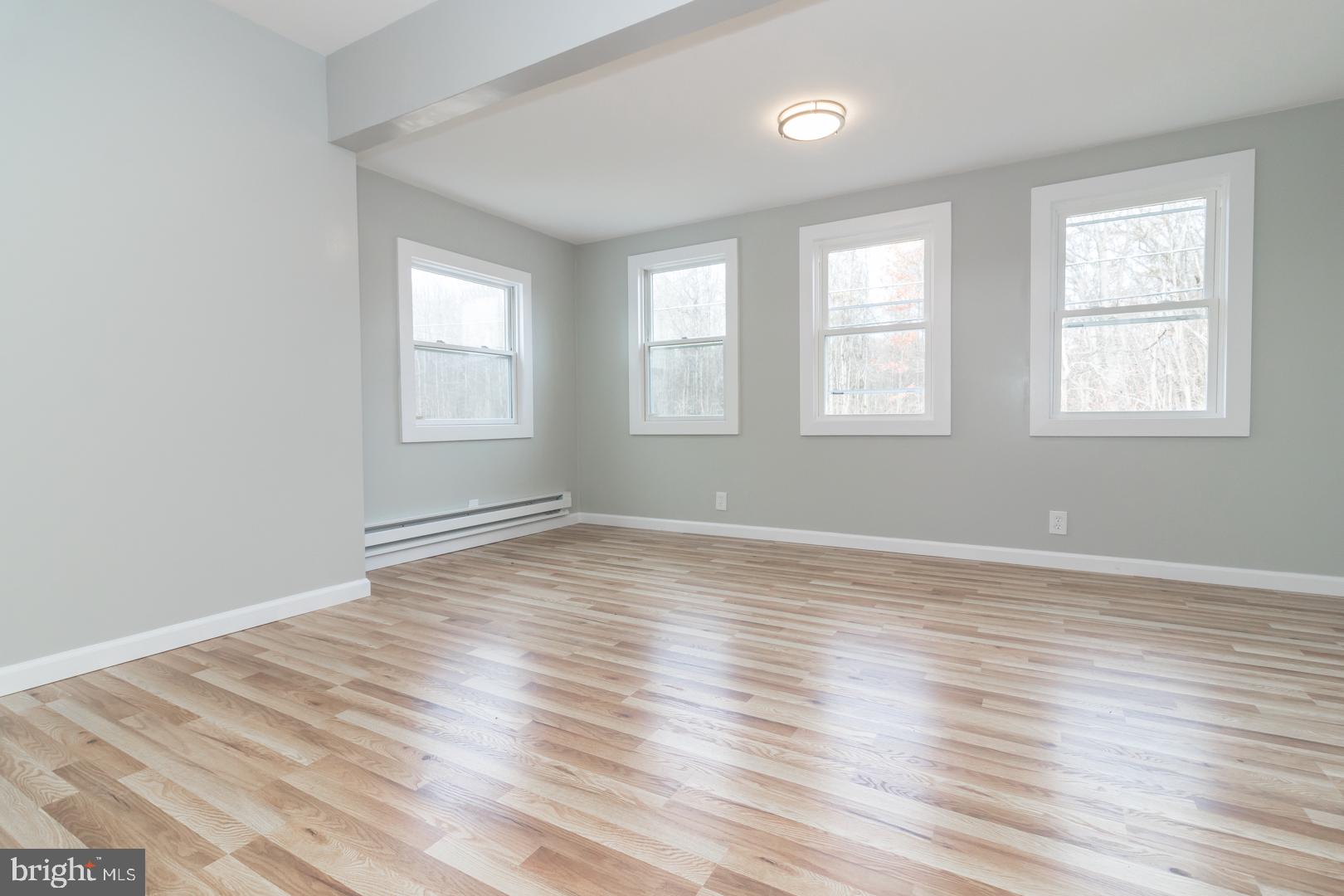 320 Fenwick Road Pilesgrove, NJ 08098 - Photo 8 of 18 an empty room with wooden floor and windows