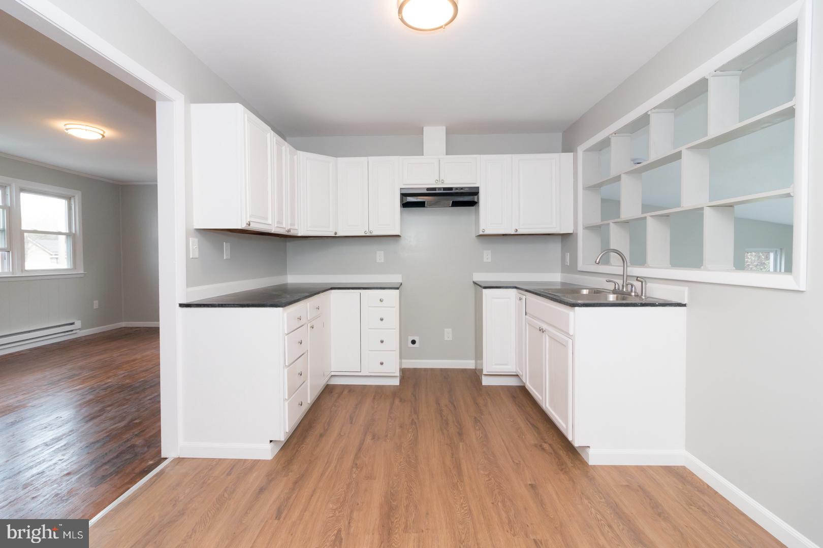 320 Fenwick Road Pilesgrove, NJ 08098 - Photo 10 of 18 a kitchen with a hard wood floor white cabinets and white appliances