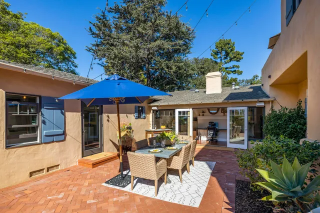 a patio with a table and chairs under an umbrella