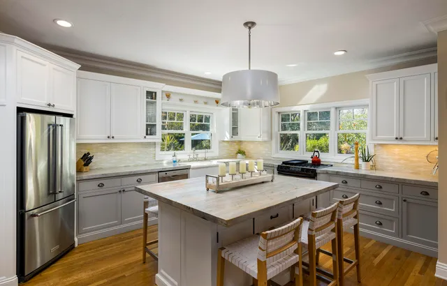 a kitchen with a center island appliances and cabinets