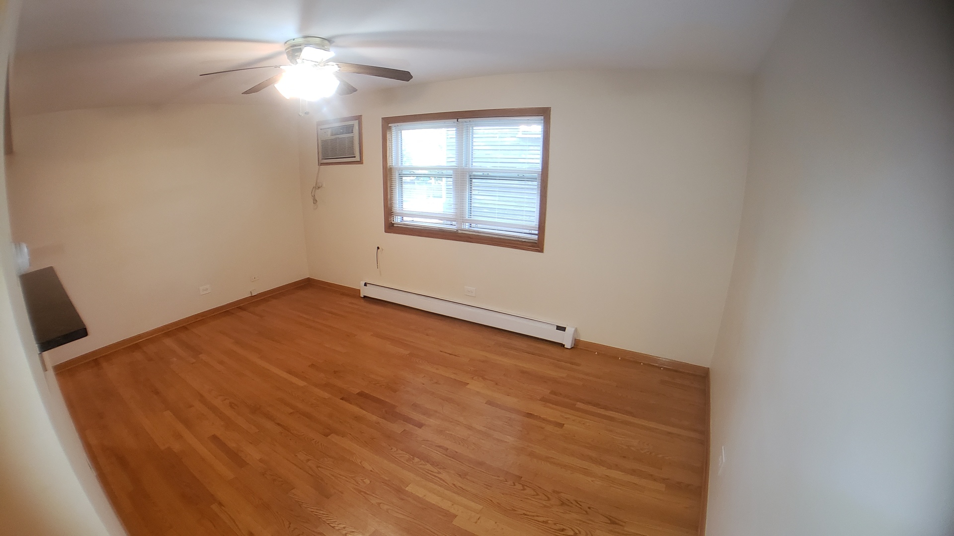 1124 Dunlop Avenue, Unit 2C Forest Park, IL 60130 - Photo 8 of 25 an empty room with windows and fan
