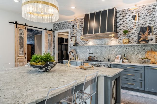 a kitchen with stainless steel appliances kitchen island granite countertop a sink stove and cabinets