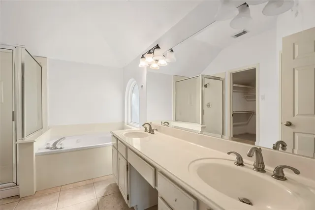 a bathroom with a sink tub double vanity and a mirror