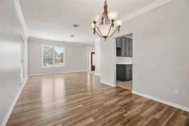 a view of empty room with wooden floor and windows