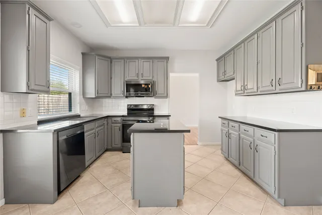a kitchen with stainless steel appliances granite countertop a sink counter space cabinets and a large window