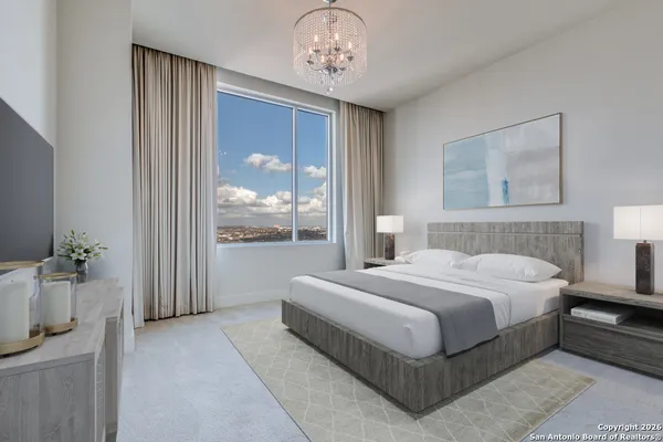 a bedroom with a large bed and a chandelier