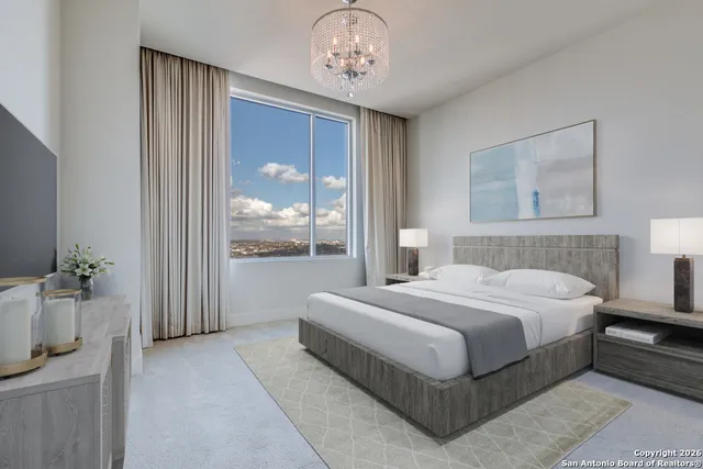 a bedroom with a large bed and a chandelier