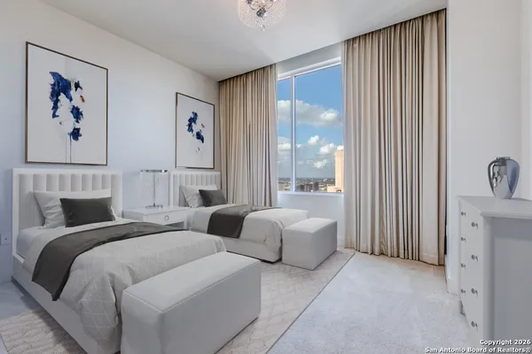 a spacious bedroom with two beds and a large window