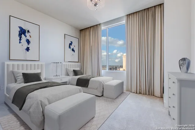 a spacious bedroom with two beds and a large window