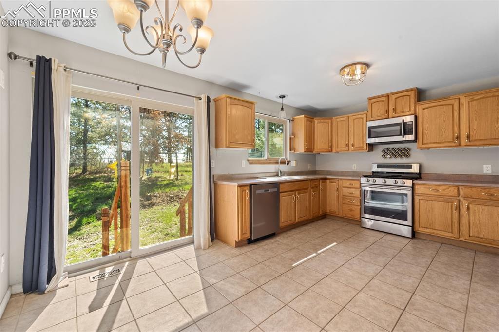 1151 Buttercup Road Elizabeth, CO 80107 - Photo 32 of 45 a kitchen with a stove a sink and a microwave