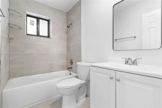 a bathroom with a toilet a sink a mirror a bathtub and vanity