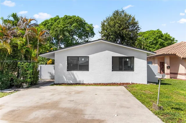 a white house that has tree in front of it
