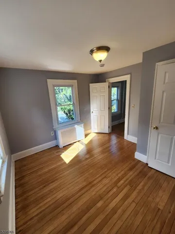 an empty room with wooden floor and window